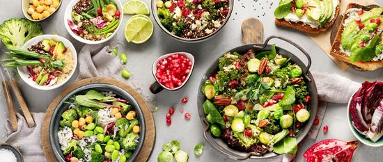 KI generiert: Das Bild zeigt eine Auswahl an gesunden, bunten Gerichten, die hauptsächlich aus frischem Gemüse, Quinoa und Granatapfelkernen bestehen. Die Anordnung betont die Vielfalt und Frische der Zutaten.