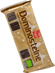 KI generiert: Das Bild zeigt eine Packung Dominosteine mit einer goldfarbenen Verpackung, die weihnachtliche Designs enthält. Die Packung wirbt mit doppelter Füllung aus Schokolade und Apfel-Fruchtfüllung.
