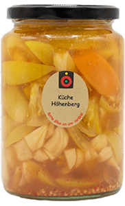 KI generiert: Das Bild zeigt ein Glas mit eingelegtem Gemüse, das mit einem Etikett der Marke "Küche Höhenberg" versehen ist. Der Hauptinhalt des Bildes ist das bunte eingelegte Gemüse im Glas.