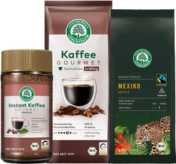 KI generiert: Das Bild zeigt drei Verpackungen von Lebensbaum-Kaffee: einen Instant-Kaffee, einen gemahlenen Gourmet-Kaffee und einen Herkunftskaffee aus Mexiko. Sie sind alle bio-zertifiziert und stammen aus nachhaltigem Anbau.