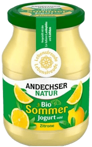KI generiert: Das Bild zeigt ein Glas mit eingelegtem Kürbis, auf dem ein Etikett mit der Aufschrift "Küche Höhenberg" angebracht ist. Der Hauptinhalt des Glases sind in Flüssigkeit eingelegte Kürbisstücke.