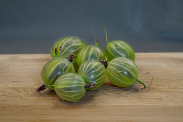 KI generiert: Mehrere Stachelbeeren liegen auf einem Holzbrett.