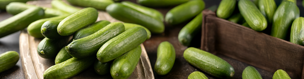KI generiert: Das Bild zeigt mehrere Pastinaken, frische und in Scheiben geschnittene, auf einer hellen Holzoberfläche. Daneben liegen einige grüne Blätter zur Dekoration.