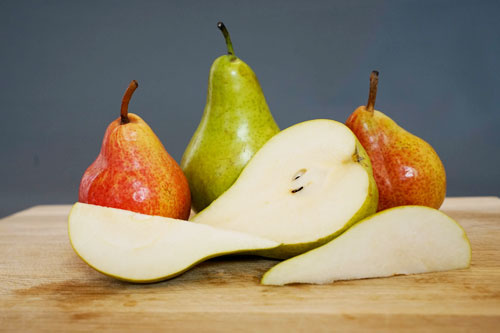 KI generiert: Birnen auf einem Holzbrett, teilweise geschnitten.