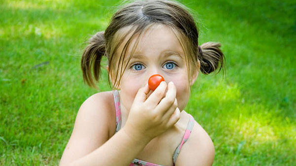 Kind mit Tomate
