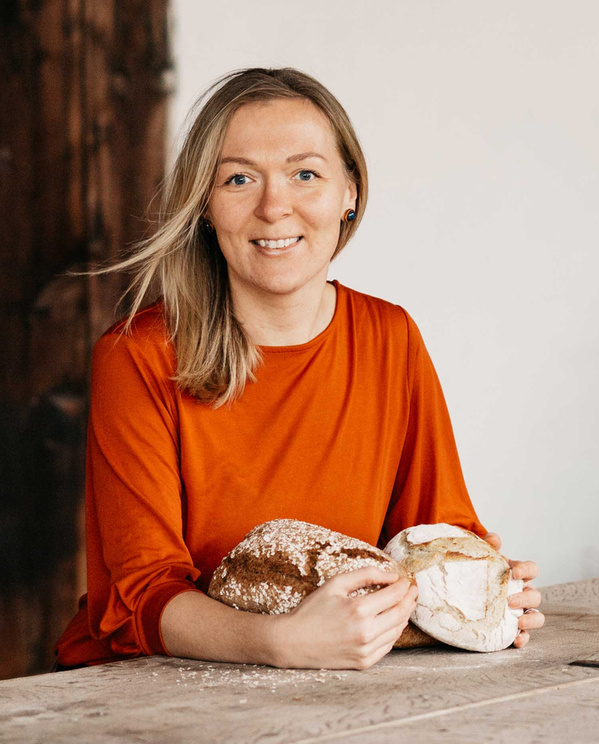 KI generiert: Eine Person hält zwei Brote und lächelt in die Kamera.