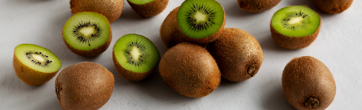 KI generiert: Kiwis, teilweise aufgeschnitten, liegen auf einem hellen Untergrund.